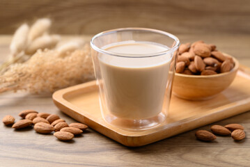 Almond milk in cup glass on wooden table, Alternative milk made from plant, non dairy