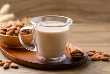 Almond milk in cup glass on wooden table, Alternative milk made from plant, non dairy