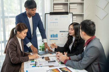 A group of people are sitting around a table with a white board in the middle