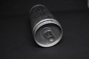 Close-up of an aluminum soda can lying on a dark background. Minimalistic and industrial design, showcasing texture and detail. Ideal for concepts of recycling, beverages, and packaging.