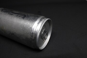 Close-up of an aluminum soda can lying on a dark background. Minimalistic and industrial design, showcasing texture and detail. Ideal for concepts of recycling, beverages, and packaging.