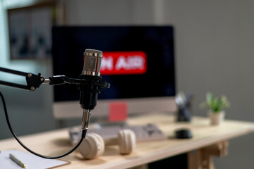 A microphone is on a desk next to a computer monitor