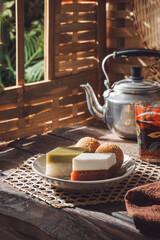 Assorted Traditional Malay Kuih. Seri Muka, Talam Gula Merah, and Kuih Bom on a Serving Plate.