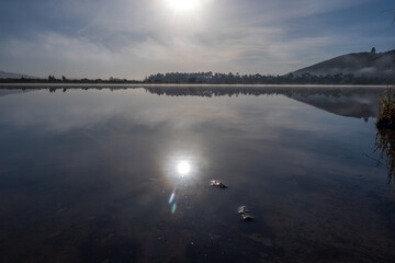 The river Taieri at sunrise where it becomes an estuary and the Historic Henley suspension bridge over the river Taieri at Otokai in the early morning