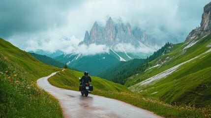 A motorbike captured mid-motion on a scenic mountain pass, surrounded by clouds rolling over alpine peaks.