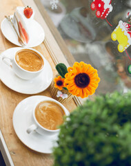 Two cups of hot coffee placed on the table in a café.