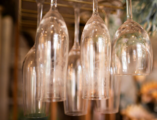 Liquor glasses hanging on shelves in restaurants