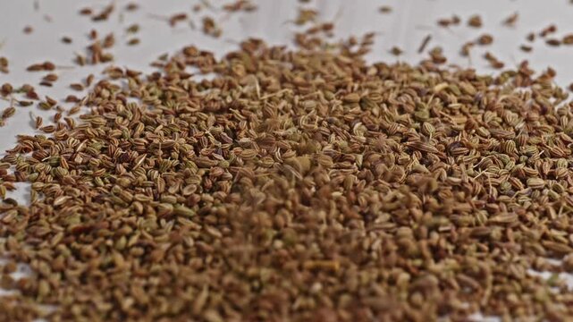 Ajwain falling on white surface and bouncing, 4k, stable shot