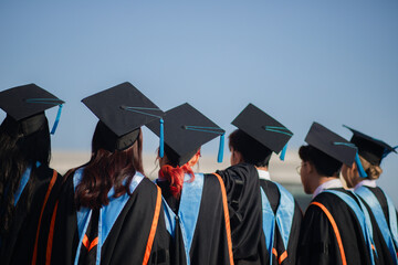 back view The group of graduates celebrated their college graduation with pride and joy on their...