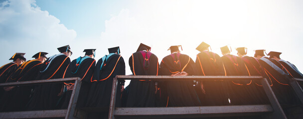 back view The group of graduates celebrated their college graduation with pride and joy on their...
