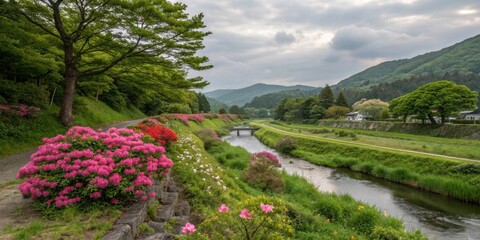 Serene river valley landscape with vibrant pink azaleas blooming alongside a tranquil waterway, under a partly cloudy sky