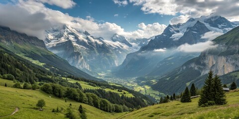 Fototapeta premium Serene Alpine Valley with Majestic Snow-Capped Peaks and Lush Green Slopes