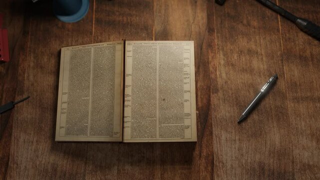 3D animation showing an old book opening on a wooden table