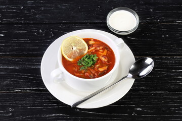 Russian meat soup Solyanka on black wooden background