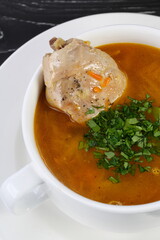 Chicken soup on wooden black background