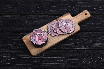 Sliced ​​bacon on black wooden background