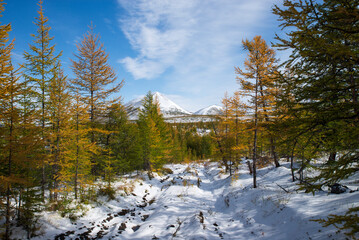 Russia. Magadan Region. Beautiful Lake Momontay against the backdrop of a snowy mountain range. Late autumn in the vicinity of Lake Momontay.