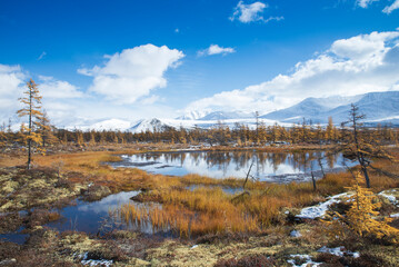 Fototapeta premium Russia. Magadan Region. Beautiful Lake Momontay against the backdrop of a snowy mountain range. Late autumn in the vicinity of Lake Momontay.