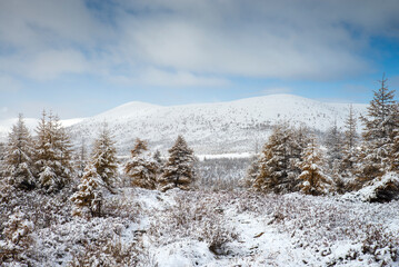 Russia. Magadan Region. Beautiful Lake Momontay against the backdrop of a snowy mountain range. Late autumn in the vicinity of Lake Momontay.