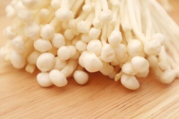 Enoki mushroom or Flammulina velutipes isolated on wooden background, close up view.
