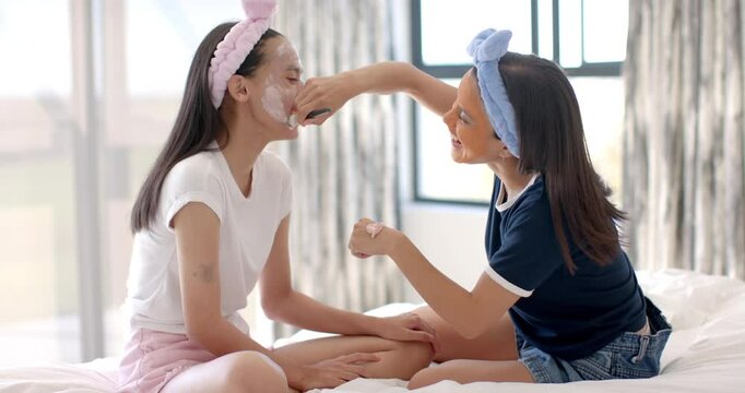 Applying face masks, two teenage girls having fun and laughing together