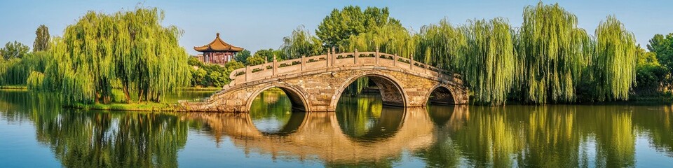 Fototapeta premium Panoramic Chinese landscape featuring an ancient bridge and willow trees in a serene setting