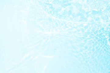 Blue water with ripples on the surface. Defocus blurred transparent blue colored clear calm water surface texture with splashes and bubbles. Water waves with shining pattern texture background.