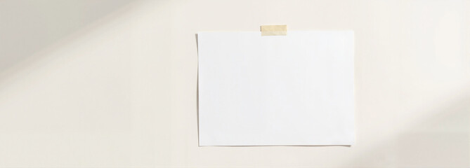 Printable paper mockup on beige wall with tape
