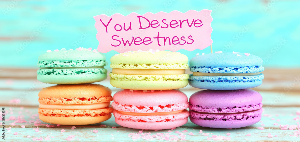 Poster you deserve sweetness with stack of colorful macarons, creating cheerful mood. these delightful trea