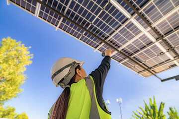 Engineer inspecting solar panels under a solar-powered carport on a sunny day, ensuring optimal...