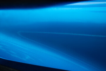 A blue car with a blue paint job. The paint job is very smooth and shiny. The car is parked in a parking lot