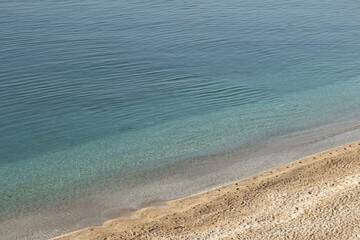 Background of blue sea, white sand and small pebbles. High quality photo