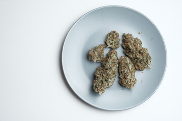 Dried marijuana buds on a plate. Wedding cake strain