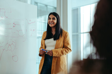 Indian businesswoman presenting at whiteboard