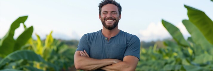 A man is smiling and standing in a field of green plants. Concept of happiness and contentment, as the man is enjoying his time in the natural setting