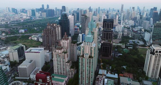 Pathum Wan District Skyline At Sunset In Bangkok, Thailand. - aerial tilt up shot