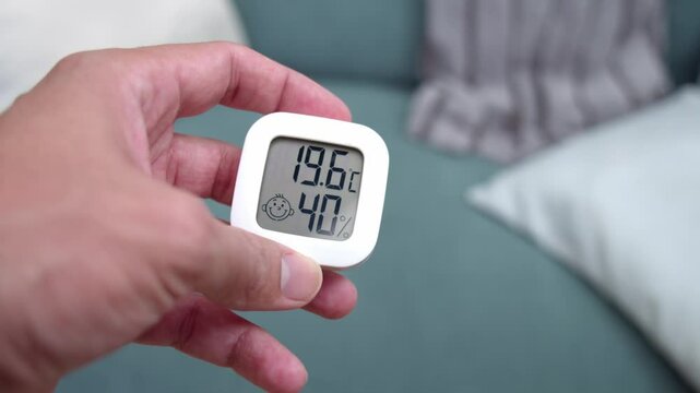 Person Holding Digital Thermo Hygrometers With Digital Display. Close-up Shot