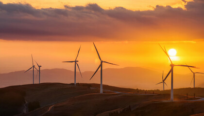 Obraz premium Wind turbines on the horizon at sunset showcasing renewable energy production