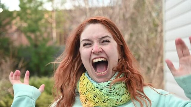 Red-haired Caucasian woman screaming in rage. 