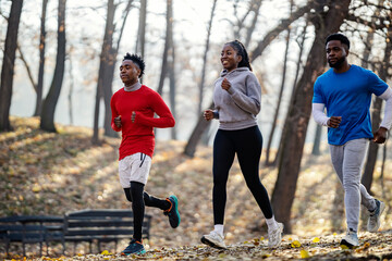 Group of interracial sportspeople running in nature.