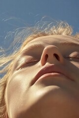 A serene close-up portrait of a young woman enjoying the warmth of the sun, radiating peace and contentment.