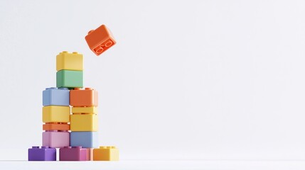 Obraz premium Tower of colorful toy blocks with one falling against a white background.