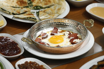 Mixed breakfast full of protein with pan-fried egg on spicy and garlicky Turkish sausage in nature
