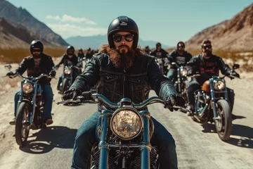 Bearded biker leading motorcycle gang riding on desert road