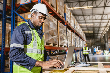 african black professional warehouse worker. stock inventory staff using computer check stock online