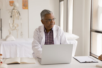 Doctor workday. Thoughtful mature male medical worker in lab coat surgeon general practitioner...