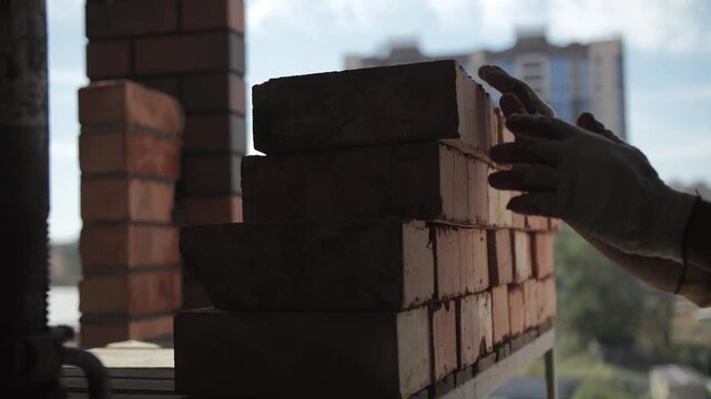 Worker stacking bricks in a neat pile