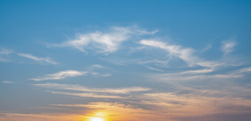 the sky is clear with fiuffy white clouds and beautiful orange light.