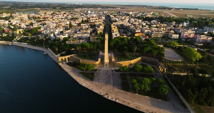 Monumento al Marinaio d'Italia With Brindisi City In The Background In Italy. - aerial shot