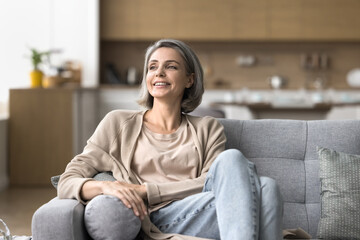 Self reliance and independence. Attractive happy mature woman in stylish casual clothing sit on...